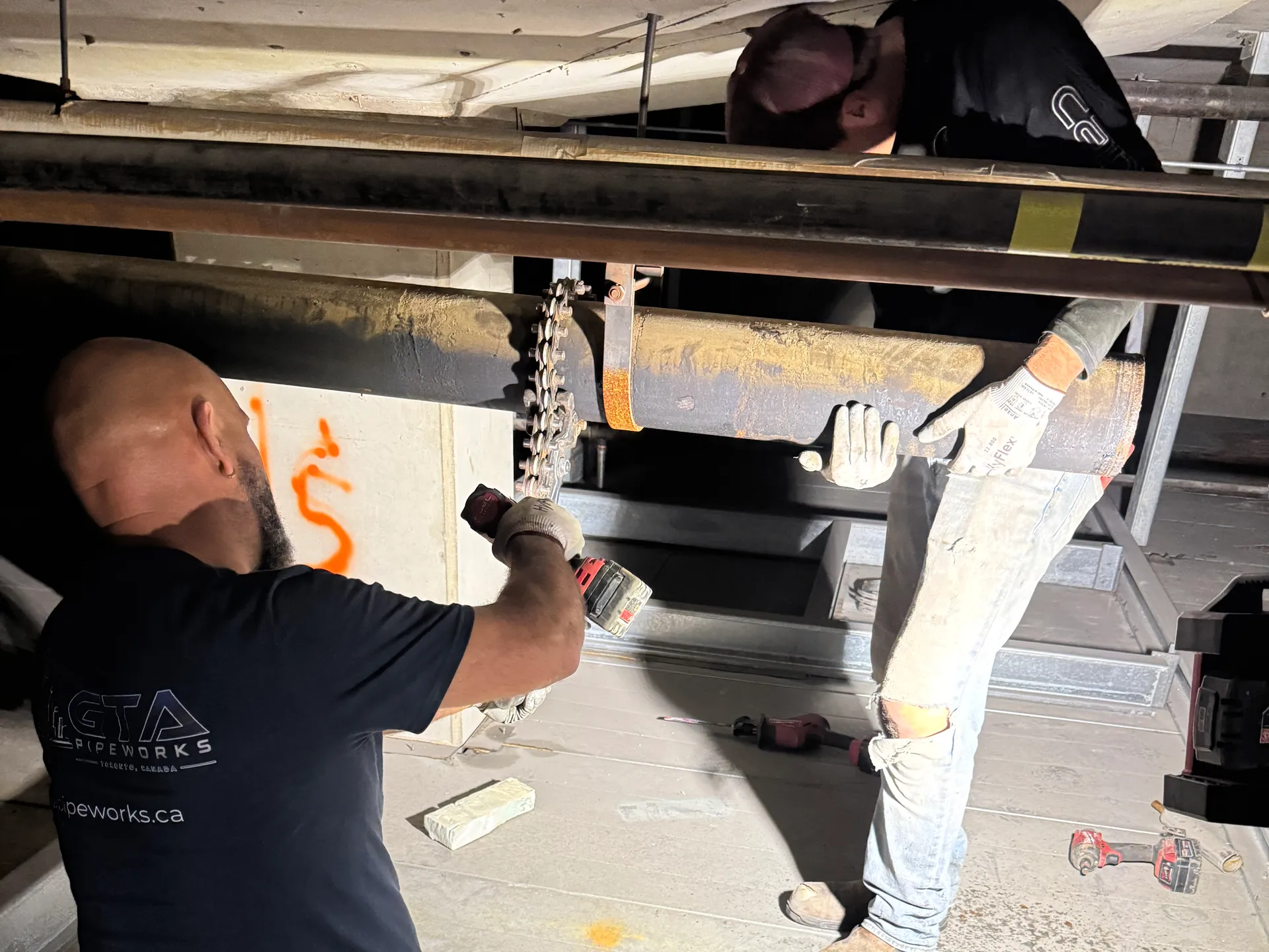 GTA Pipeworks crew cutting out old cast iron pipe at the Metro Toronto Convention Centre