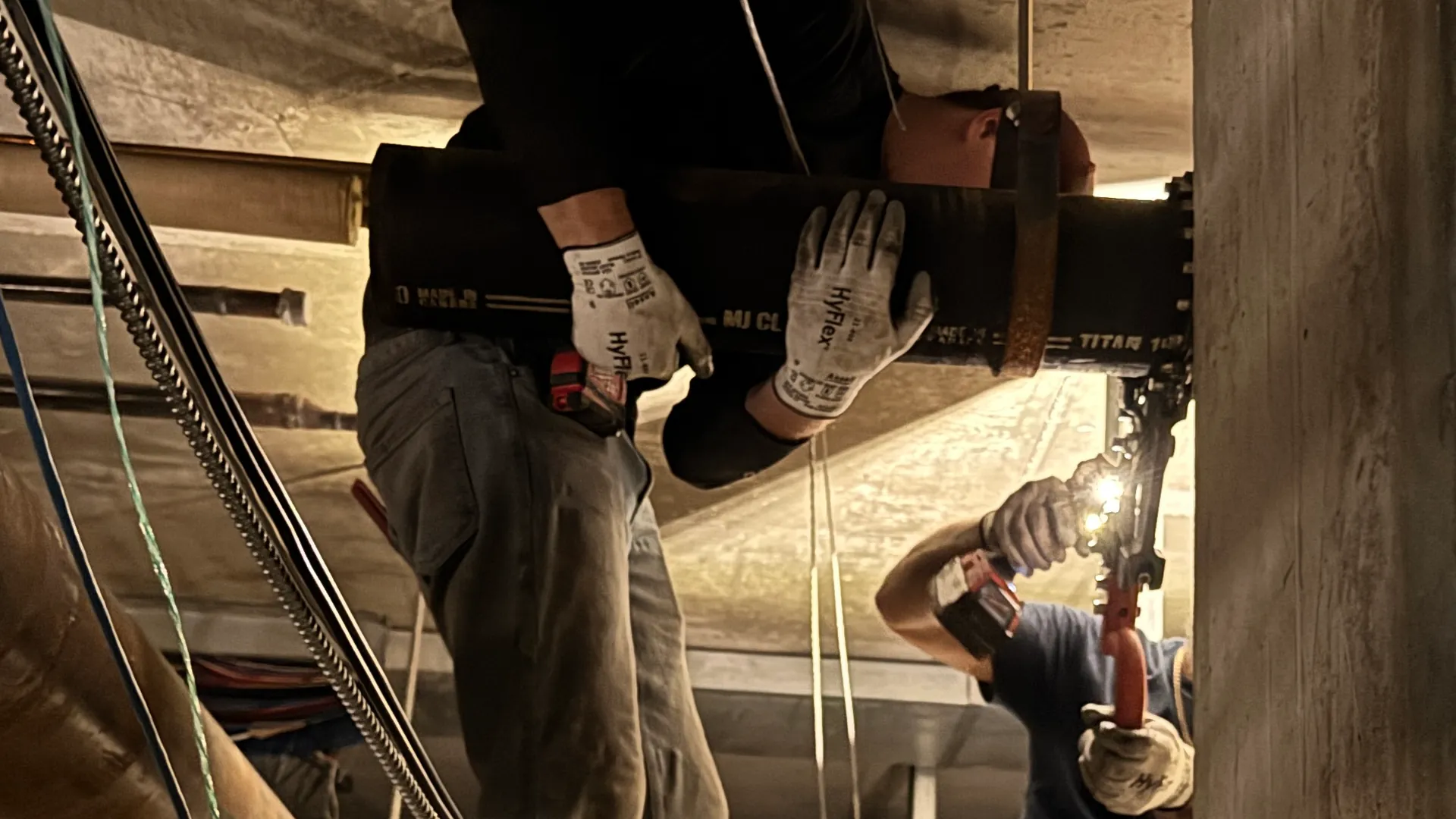 GTA Pipeworks plumbers cutting out a section of cast iron pipe overhead at the Metro Toronto Convention Centre